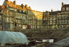 Vue g&eacute;n&eacute;rale du chantier.  Seules les fa&ccedil;ades des immeubles construits au XVIIIe si&egrave;cle ont &eacute;t&eacute; conserv&eacute;es dans le projet de construction. Encadrant l'emprise de la fouille, elles apparaissent ici contrefort&eacute;es de bois en attendant la construction du nouveau march&eacute; couvert.