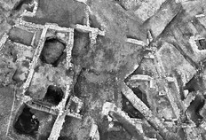 Vue d'ensemble du site en cours de fouille en 1995. En haut &agrave; droite, l'entr&eacute;e de l'amphith&eacute;&acirc;tre, qui a servi de porte de ville au Moyen &Acirc;ge, est travers&eacute;e par la rue Saint-Jacques (de haut en bas : de l'angle &agrave; droite au milieu du clich&eacute;).  Les espaces bordant la rue sont occup&eacute;s par des maisons &eacute;difi&eacute;es entre le XVIe et le XVIIIe si&egrave;cle, dont on peut voir les caves et les fondations.