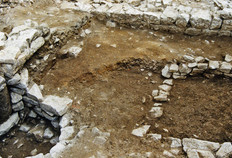 Vue d'une cave m&eacute;di&eacute;vale situ&eacute;e &agrave; l'arri&egrave;re d'une maison qui bordait la place Bacchus.  Une fosse ma&ccedil;onn&eacute;e quadrangulaire et un puits y sont am&eacute;nag&eacute;s. On distingue un fragment de colonne antique r&eacute;employ&eacute; dans le parement du puits, contre le mur de la cave.