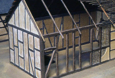 Proposition de restitution de deux maisons gauloises de la première phase d'occupation du site (120 à 40 avant notre ère). La structure en pan de bois sur sablière basse était sans doute remplie de torchis. Maquette J. Parreaux et G. Mauguin, Besançon.