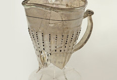 Pichet en verre décoré de côtes verticales ponctuées de perles d'émail, provenant du comblement d'une citerne du XVIe siècle rue de Vignier.