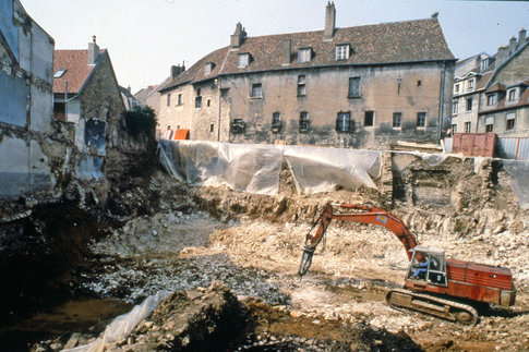 Vue générale du chantier de la rue de Vignier en cours de fouille. À l'arrière, s'élève l'hôtel Jouffroy, construit au XVe siècle, dont les fenêtres du rez-de-chaussée sont protégées par des grilles. © J.-O. Guilhot, SRA de Franche-Comté