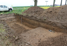 D&eacute;p&ocirc;t mon&eacute;taire du IIIe si&egrave;cle de notre &egrave;re.  Il &eacute;tait localis&eacute; &agrave; une dizaine de m&egrave;tres au sud de la voie romaine reliant Amiens (Samarobriva) &agrave; Cambrai (Camaracum), via Bapaume. Cette voie est aujourd'hui mat&eacute;rialis&eacute;e par la route goudronn&eacute;e actuelle. Le creusement situ&eacute; entre la voie et le tr&eacute;sor mon&eacute;taire est un chemin creux fonctionnant simultan&eacute;ment avec la voie romaine durant le Haut-Empire.  Derri&egrave;re Les Haies, Lahoussoye (Somme), 2012