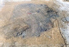 Vue d'une fosse-silo protohistorique avant sa fouille manuelle.  En p&eacute;riph&eacute;rie, on remarque les traces des poteaux qui constituaient autrefois une ossature.  Le Chemin de Couturelle, Coullemont (Pas-de-Calais), 1997.&nbsp;