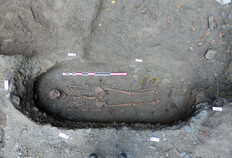 Vue d'une s&eacute;pulture en fin de fouille. Une paire de chaussures en cuir &agrave; semelle clout&eacute;e accompagnait le d&eacute;funt dans l'au-del&agrave;. Retrouv&eacute;es gr&acirc;ce &agrave; la pr&eacute;sence des nombreux clous rouill&eacute;s encore en place, elles sont mat&eacute;rialis&eacute;es ici par un trait jaune.  Parc des Tanneurs, Rennes (Ille-et-Vilaine), 2017/2018  &copy; &Eacute;quipe de fouille Inrap