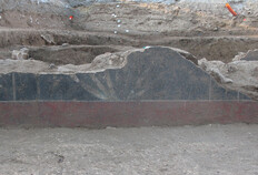 Peinture murale conserv&eacute;e sur pr&egrave;s d'un demi-m&egrave;tre de hauteur. Au-dessus d'une plinthe de couleur rouge ocre, d&eacute;cor d'une touffe v&eacute;g&eacute;tale &agrave; huit longues feuilles pointues se d&eacute;veloppant en &eacute;ventail peint avec des nuances de vert clair &agrave; blanc sur fond noir. Sur la gauche, motif de fleuron.  Parking Jean-Jaur&egrave;s, N&icirc;mes (Gard), 2007 