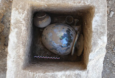 Coffre monolithe en pierre contenant un vase ossuaire en verre et de nombreux d&eacute;p&ocirc;ts d'objets.  1 bis rue de l'Abattoir, N&icirc;mes (Gard), 2022  &copy; Sarah Beiger, Inrap