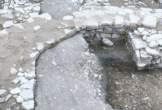 Lambeau de la rue, Ier si&egrave;cle avant J.-C.  La surface empierr&eacute;e compacte d'une partie de la rue tardo-r&eacute;publicaine a &eacute;t&eacute; retrouv&eacute;e entre l'excavation de fondation du podium et l'escalier d'acc&egrave;s du temple du Haut Empire. Deux orni&egrave;res parall&egrave;les sont encore visibles &agrave; la surface de la chauss&eacute;e.  N&icirc;mes, Ancien th&eacute;&acirc;tre (Gard), 1985.&nbsp; &nbsp;  &copy; Francis Cognard, Fonds Arch&eacute;Ofactory