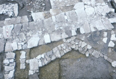 Bassin hexagonal, Ier si&egrave;cle avant J.-C.  L'am&eacute;nagement &agrave; la forme singuli&egrave;re est dot&eacute; d'une canalisation b&acirc;tie qui devait permettre d'&eacute;vacuer les eaux depuis une bonde &agrave; l'int&eacute;rieur de la cuve, non conserv&eacute;e, du bassin. Il s'agit d'un am&eacute;nagement d'agr&eacute;ment dans un jardin ou une cour.  N&icirc;mes, Ancien th&eacute;&acirc;tre (Gard), 1985.  &copy; Francis Cognard, Fonds Arch&eacute;Ofactory