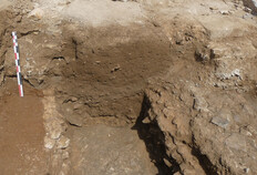 Un sondage r&eacute;alis&eacute; perpendiculairement au trac&eacute; de la rue antique a r&eacute;v&eacute;l&eacute; un grand &eacute;gout dont les mat&eacute;riaux de construction ont &eacute;t&eacute; r&eacute;cup&eacute;r&eacute;s (centre de l'image). &Agrave; droite de l'image, un bloc de taille rectangulaire install&eacute; horizontalement sur une semelle de fondation constitue la base d'un pilier qui, associ&eacute; &agrave; d'autres, devait constituer un portique en fa&ccedil;ade d'un des b&acirc;timents antiques.  Troisi&egrave;me quart du Ier si&egrave;cle � milieu IIe si&egrave;cle  Rue Porte-de-France, &icirc;lot Saint-Joseph 3, Palais des Congr&egrave;s, N&icirc;mes (Gard), 2022.