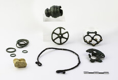 Objets d&eacute;pos&eacute;s dans une tombe d'enfant&nbsp;: embout moulur&eacute;, anneaux, rouelle, bo&icirc;te &agrave; rouelle, agrafe avec incrustations de corail (bronze)&nbsp;; osselet perc&eacute;&nbsp;(ovin); petit torque (fer).  Seconde moiti&eacute; du IIIe si&egrave;cle avant J.-C.  12 rue de Saint-Gilles, N&icirc;mes (Gard), 2014.  &copy; Christophe C�uret, Inrap