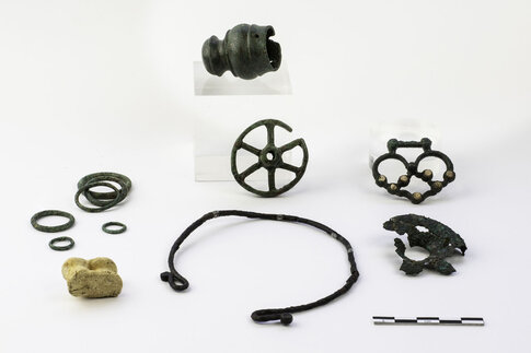 Objets d&eacute;pos&eacute;s dans une tombe d'enfant&nbsp;: embout moulur&eacute;, anneaux, rouelle, bo&icirc;te &agrave; rouelle, agrafe avec incrustations de corail (bronze)&nbsp;; osselet perc&eacute;&nbsp;(ovin); petit torque (fer).  Seconde moiti&eacute; du IIIe si&egrave;cle avant J.-C.  12 rue de Saint-Gilles, N&icirc;mes (Gard), 2014.  &copy; Christophe C�uret, Inrap 