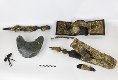 Mobilier associ&eacute; &agrave; la tombe d'un probable militaire gaulois : panoplie guerri&egrave;re comprenant une pointe de lance, l'umbo et la manipule d'un bouclier, une &eacute;p&eacute;e repli&eacute;e dans son fourreau (fer), accompagn&eacute;s d'un probable plastron en bronze poss&eacute;dant 28 trous de rivetage. Dans l'ossuaire, une grande fibule en fer a &eacute;t&eacute; mise au jour.  IIIe si&egrave;cle avant J.-C.  12 rue de Saint-Gilles, N&icirc;mes (Gard), 2014.  &copy; Christophe C�uret, Inrap