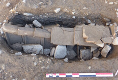 Tombe des Ve-VIe si&egrave;cles en cours de fouille, caract&eacute;ris&eacute;e par sa couverture de tuiles plates agenc&eacute;es en b&acirc;ti&egrave;re et recouverte par des tuiles &agrave; plat sur le fa&icirc;tage. &Agrave; l'une des extr&eacute;mit&eacute;s, une tuile plate dispos&eacute;e verticalement permettait de signaler l'emplacement de la tombe.  12 rue de Saint-Gilles, N&icirc;mes (Gard), 2014.  &copy; Julie Grimaud, Inrap
