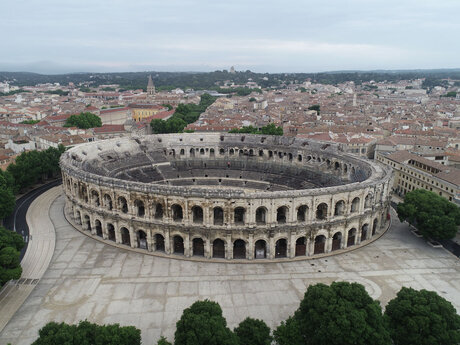 L'Amphith&eacute;&acirc;tre de N&icirc;mes  Au premier plan, sur l'esplanade, on distingue le trac&eacute; de l'enceinte romaine, flanqu&eacute;e de deux tours.  I-IIe si&egrave;cle apr&egrave;s J.-C.  Amphith&eacute;&acirc;tre, suivi arch&eacute;ologique de la restauration, N&icirc;mes (Gard), 2023  &copy; Vincent Lauras, Inrap 